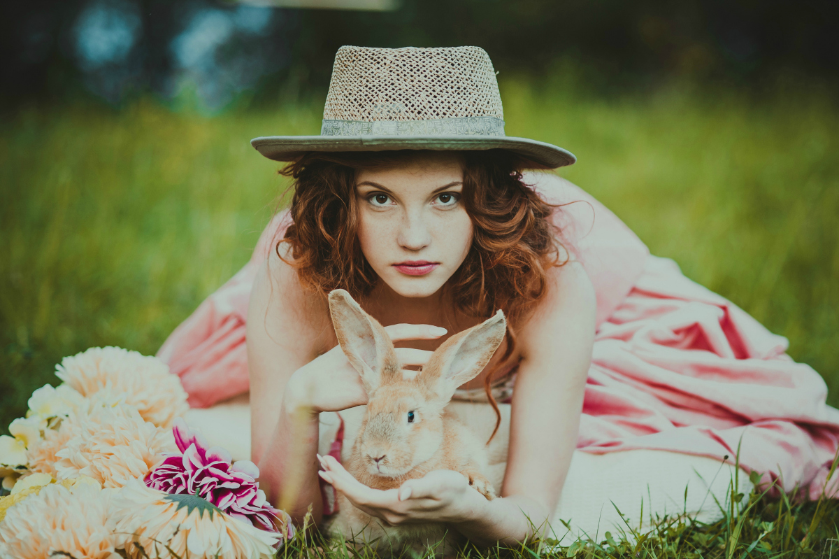 beautiful girl with a rabbit outdoors in summer day